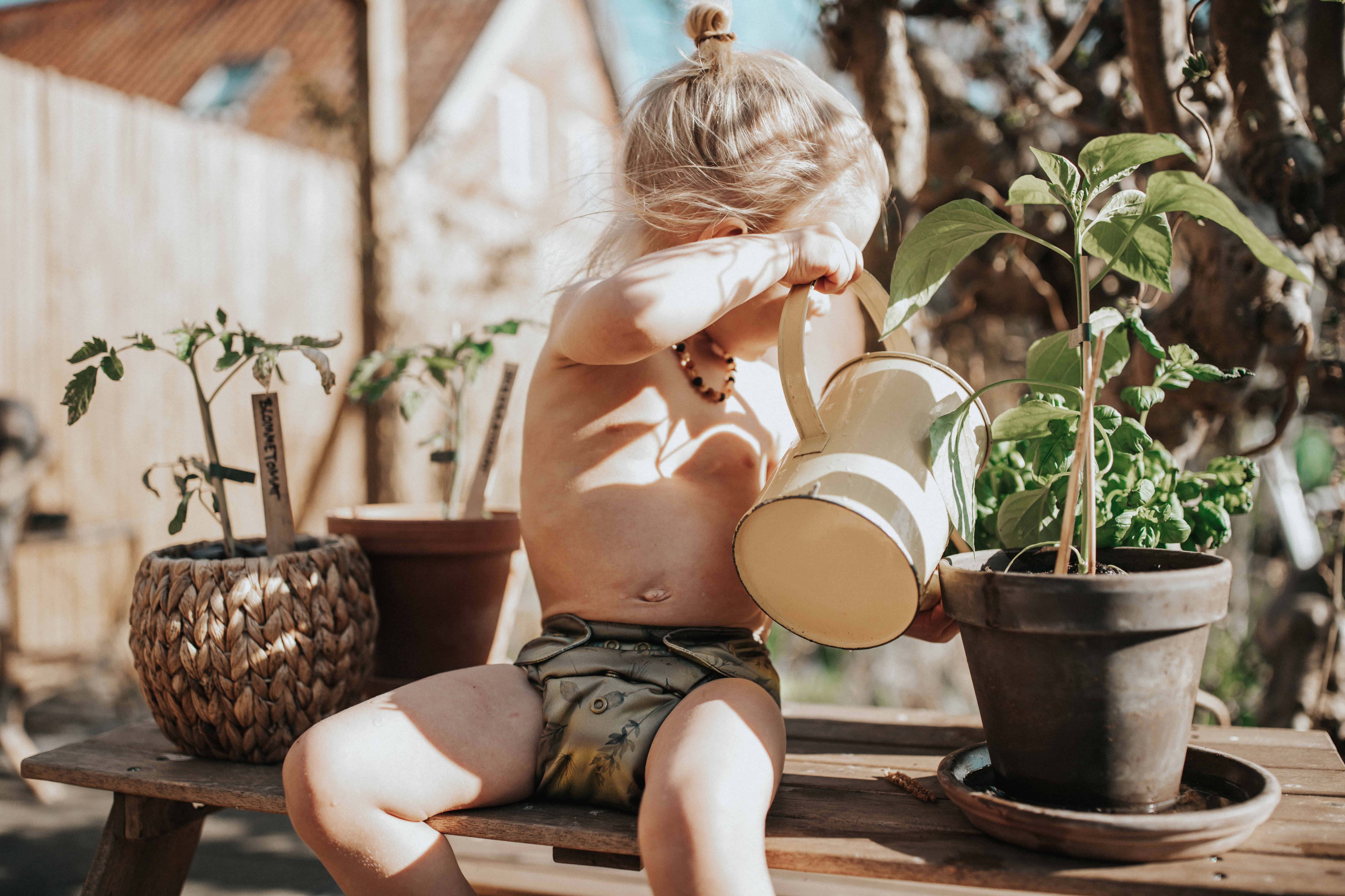 boy with cloth diaper watering plants